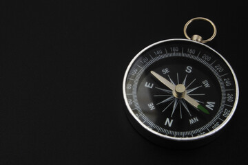 Round compass on black background close-up. Travel, find destination and navigation concept.