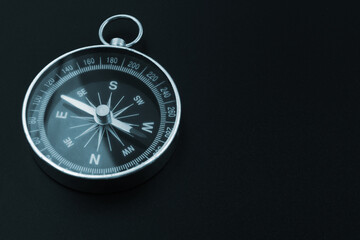 Round compass on black background, copy space for text. Trip and find destination concept.