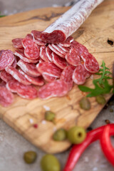 Sliced Spanish sausage fuet salami and vegetables on a domestic kitchen