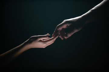 Two hands reaching toward. Tenderness, tendet touch hands in black background. Romantic touch with fingers, love. Hand creation of adam. - obrazy, fototapety, plakaty