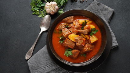 Beef goulash, soup and a stew, made of beef chuck steak, potatoes and plenty of paprika. Hungarian  traditional meal. - obrazy, fototapety, plakaty