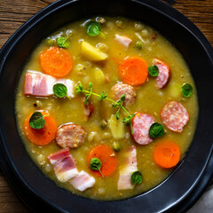 Hearty rustic pea soup with bacon and sausage