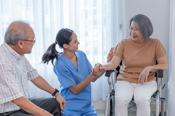 Young nurse taking care elderly disabled woman sitting in a wheelchair with copyspace.