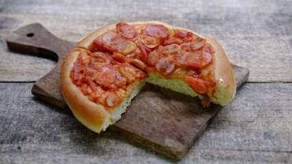 Pepperoni pizza bread on a cutting board on wooden background