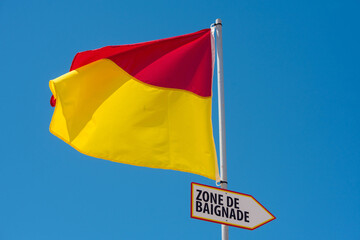 yellow and red flag delimiting the supervised bathing area