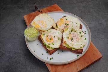 Avocado fried egg sandwich with bread on wooden floor home made