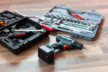 Box with electrician tools on wooden background.