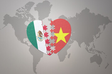 puzzle heart with the national flag of vietnam and mexico on a world map background.Concept.