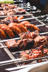 Grilled meat, vegetables and sausages on skewers