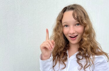 a girl on a white background in a white blouse, fair-haired, shows different cheerful emotions, she...