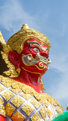 A giant red-colored statue guarding the temple.