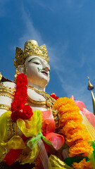 A white angel statue stands guarding the temple.