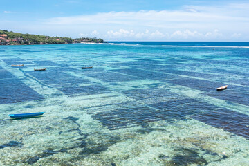Aerial view of Nusa lembongan seaweed field farming background  as local boat in Bali, Indonesia