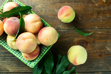 Ripe peaches in basket on wooden background. Home harvest from your own garden.