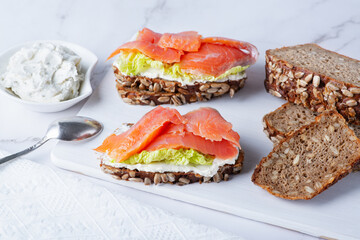 Healthy toasts with rye bread with cream cheese, salmon and salad