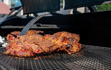 slow cooked beef brisket meat on the grill grates of a smoker barbecue