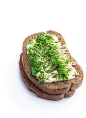 Wholemeal toastwith soft cheese and a lot of cress salad isolated on white