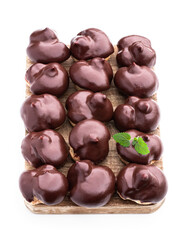 Homemade profiteroles covered with chocolate isolated on white