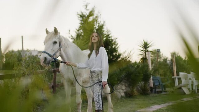 Girl poses for a newspaper together with her beautiful white horse