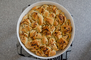 Fresh yeast pie with fried onions. In a white brazier close-up flat lay