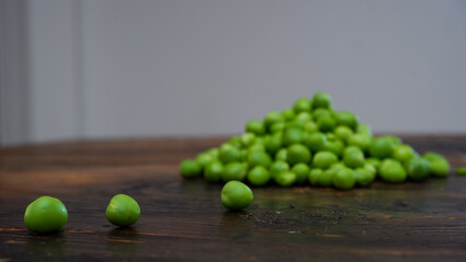 Fresh peeled green pease on a brown wooden table with copy space. Still life of green peas in pods with pea shoots on wooden table