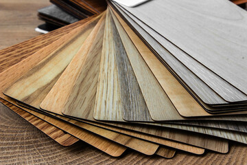 Obraz na płótnie Canvas Sample of wood laminated chipboard for furniture design on wooden background with copy space. Color guide displaying a range of hues for use in interior design and decoration, for designers.