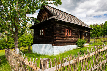 Fototapeta na wymiar Skansen with wooden village houses near Sara Lubovna Castle in Slovakia at summer