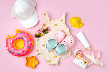 Fashion swimsuit, sunglasses, beach slippers and sunscreen for children. Top view of beach...