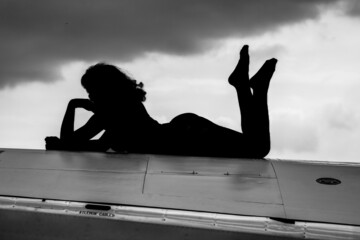 sexy silhouette of a woman on a spitfire wing - obrazy, fototapety, plakaty