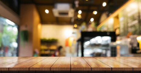 Empty wooden table top with lights bokeh on blur restaurant background.