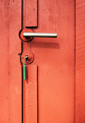 Metal handle and key on red cabin door