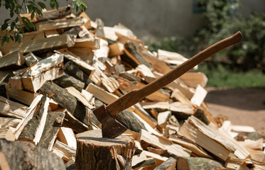 Ax on the background of chopped firewood for kindling the stove