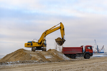 Fototapeta na wymiar Yellow excavator working on construction site. The road construction.