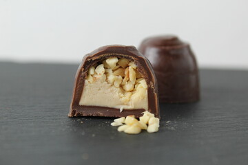 chocolate case candy in section with praline peanuts crushed on a gray background close-up. A day...