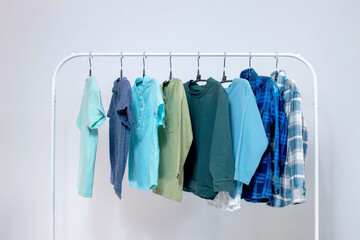 Rack with stylish children's clothes on hangers for a preschool boy. Wardrobe for a little boy