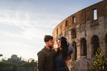 Young romantic couple having tender moment in front of Rome Colosseum