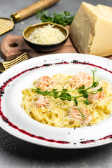 Pasta with grilled shrimps, bechamel sauce, cheese and microgreen, italian cuisine, Food recipe background. Close up. vertical image. top view. place for text