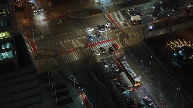 Samochody w centrum miasta noca przejeżdzają przez skrzyzowanie