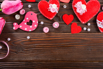 Sewed handmade fabric hearts tulips and ribbon for valentine day on dark wooden background with copy space