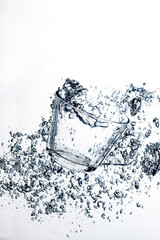 transparent glass dropped into the water on a white background