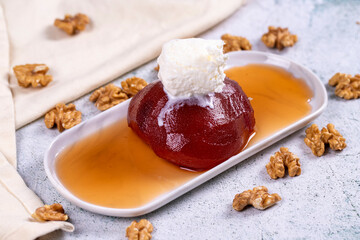 Quince dessert. Traditional Turkish cuisine delicacies. Quince dessert with cream on a stone background. Close-up. local name ayva tatlisi