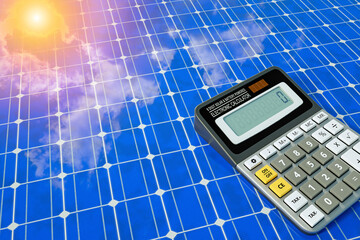 electronic calculator on solar panel with beautiful reflection of bright blue sky and sun....