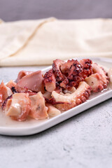 Octopus salad. Mediterranean cuisine delicacies. Octopus arms with olive oil on stone background. Close-up