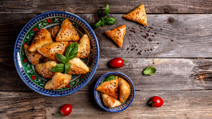 Traditional Indian cuisine samosas baked pastry with savoury filling, popular Indian snacks with spices on rustic background, top view
