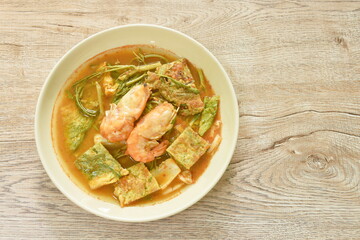 boiled shrimp and fried egg stuffed climbing wattle vegetable in spicy sour soup on plate