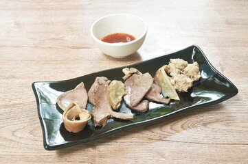 boiled entrails with chop pork on black plate dipping spicy and sour chili sauce