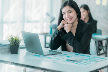 Businesswoman or accountant using the phone to check business information. Accounting Documents and Laptop Computer at Office Business Ideas