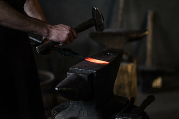 blacksmith hitting a red-hot iron with a hammer