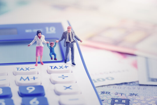 Family tax benefit or FTB / child care fee concept : Couple holds a child on a calculator, depicts a social security payment which is distributed to the parents or guardians of children or teenagers.