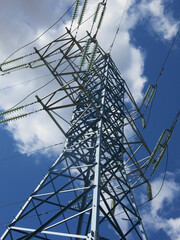 geometric design of a power line tower against a blue sky background